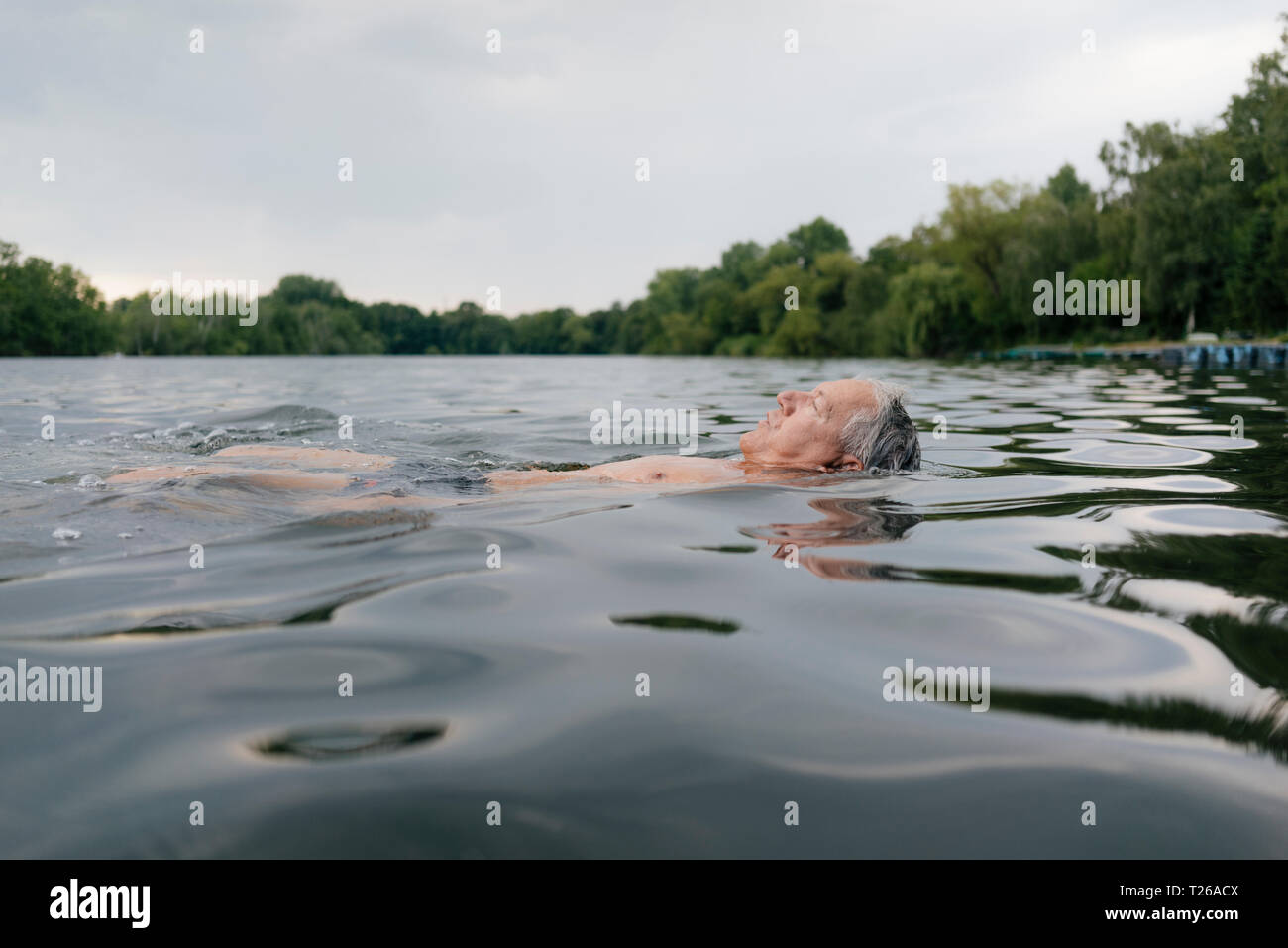 Senior man swimming in a lake Banque D'Images