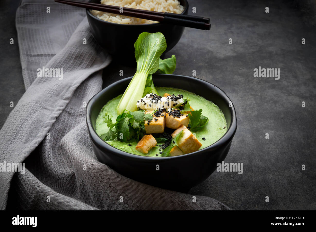 Thai au curry vert épinards, pak choi, tofu, crème sure, sésame noir et riz au jasmin Banque D'Images