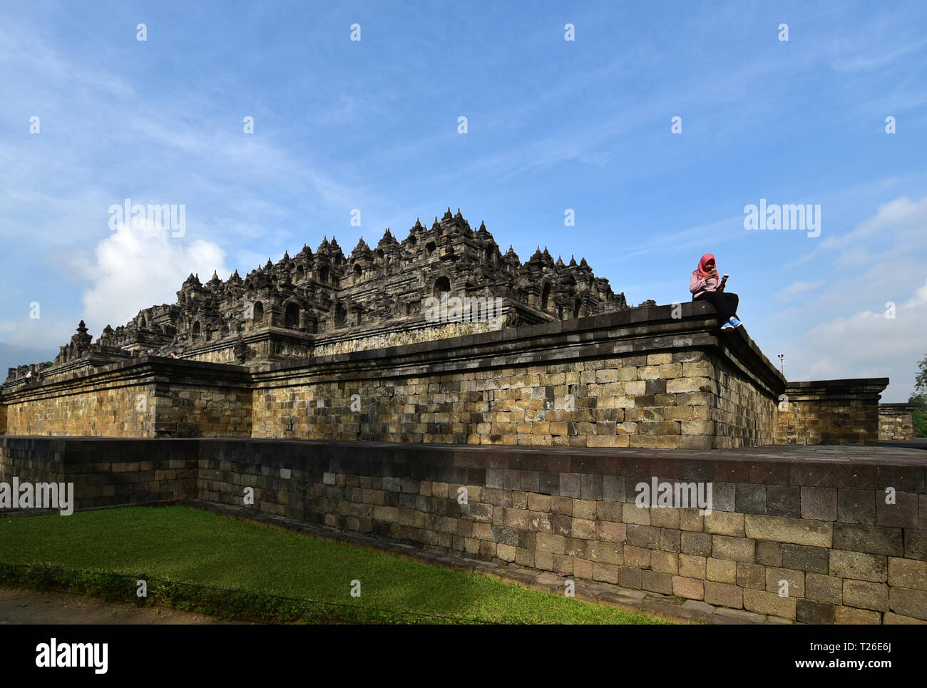 BOROBUDUR, INDONÉSIE- 08,23.2017. Young indonesian woman using smartphone dans le temple de Borobudur. Banque D'Images