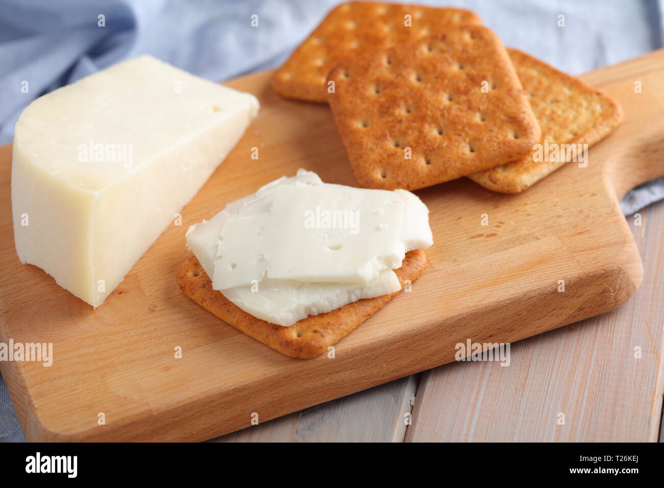 Les crackers au Gouda Fromage de lait de chèvre sur une planche à découper en bois Banque D'Images