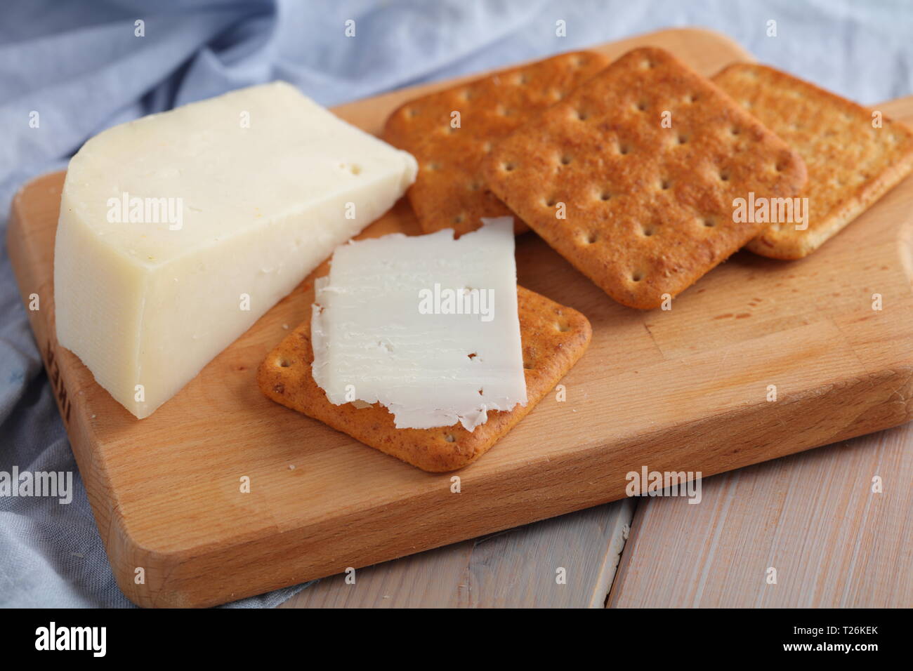 Les crackers au Gouda Fromage de lait de chèvre sur une planche à découper en bois Banque D'Images