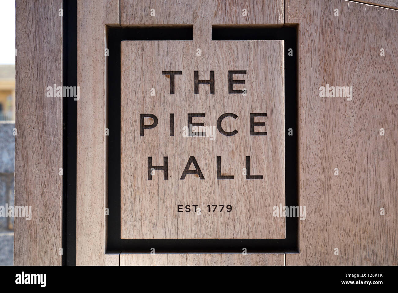 La Pièce Hall logo dans la partie bois d'un banc public dans le quadrilatère de la place centrale . Graines de soleil et ciel bleu. Halifax, West Yorkshire, Royaume-Uni. (106) Banque D'Images