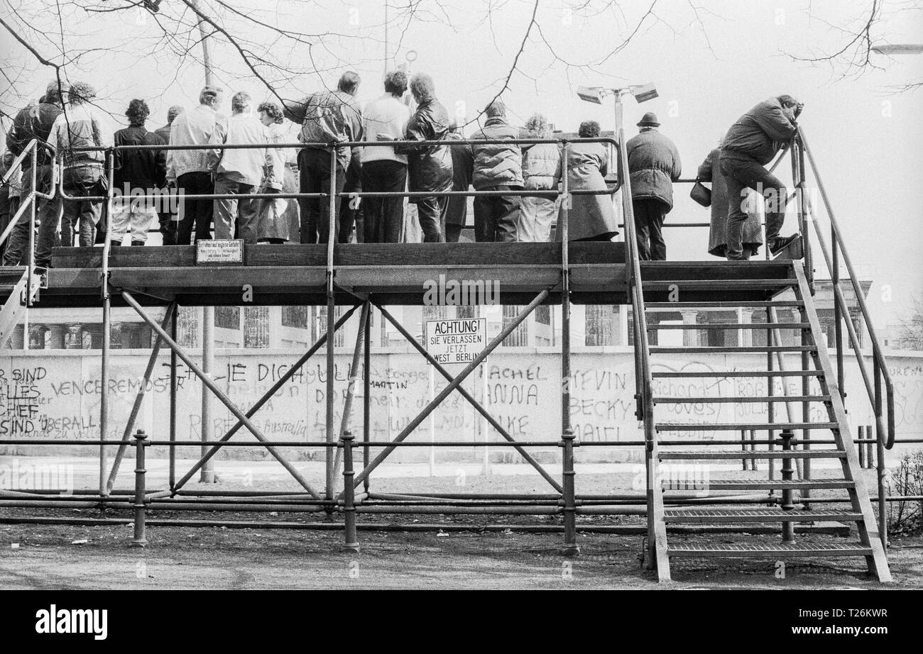 L'Allemagne de l'Ouest, Berlin Ouest, le mur en l'an 1988, les visiteurs sur la plate-forme d'observation sur la porte de Brandebourg à Berlin Ouest Berlin Est de vision latéral côté en RDA , numérisation à partir de 35 mm noir et blanc Banque D'Images