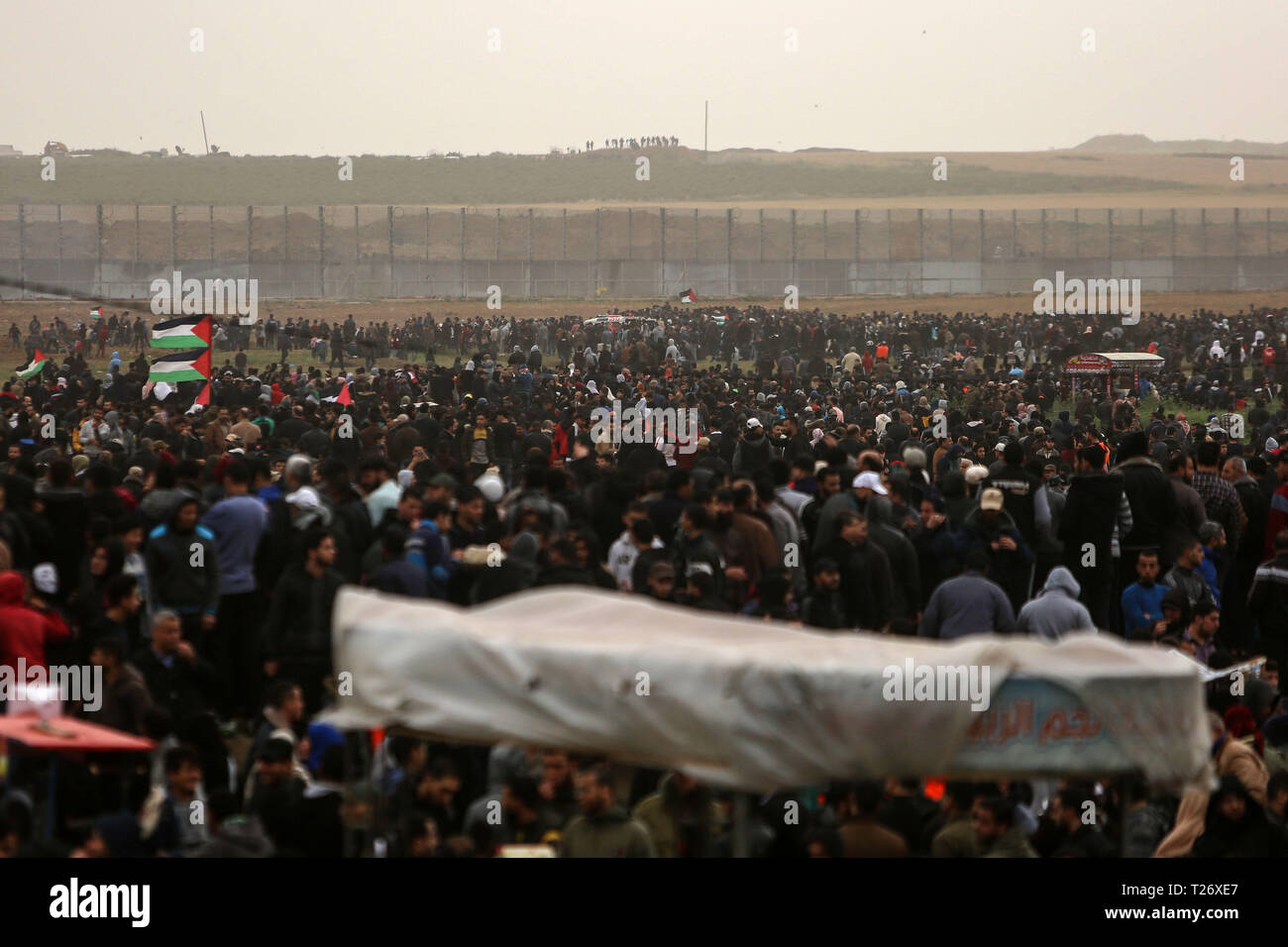La bande de Gaza. 30Th Mar, 2019. Des manifestants palestiniens en conflit avec les troupes israéliennes sur la frontière Gaza-Israel, est de la ville de Gaza, le 30 mars 2019. Des milliers de Palestiniens a marqué le samedi le jour de la terre palestinienne et le premier anniversaire de la grande marche du retour des Palestiniens. Credit : Stringer/Xinhua/Alamy Live News Banque D'Images