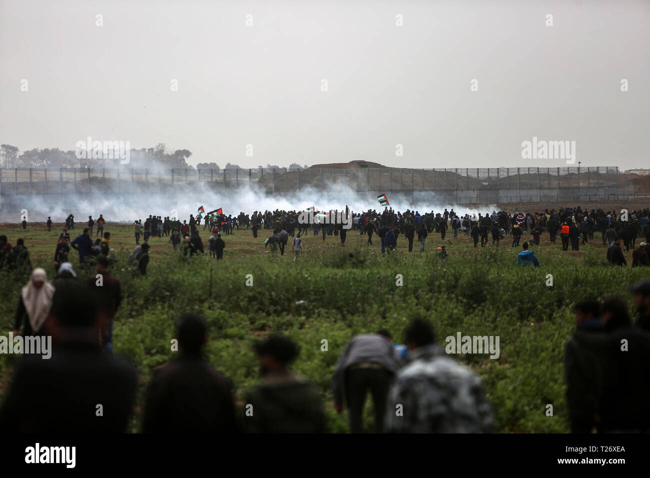 La bande de Gaza. 30Th Mar, 2019. Des manifestants palestiniens en conflit avec les troupes israéliennes sur la frontière Gaza-Israel, est de la ville de Gaza, le 30 mars 2019. Des milliers de Palestiniens a marqué le samedi le jour de la terre palestinienne et le premier anniversaire de la grande marche du retour des Palestiniens. Credit : Stringer/Xinhua/Alamy Live News Banque D'Images