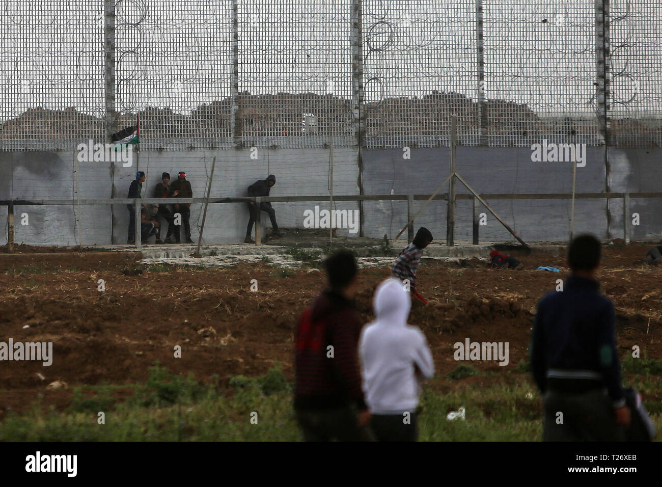 La bande de Gaza. 30Th Mar, 2019. Des manifestants palestiniens en conflit avec les troupes israéliennes sur la frontière Gaza-Israel, est de la ville de Gaza, le 30 mars 2019. Des milliers de Palestiniens a marqué le samedi le jour de la terre palestinienne et le premier anniversaire de la grande marche du retour des Palestiniens. Credit : Stringer/Xinhua/Alamy Live News Banque D'Images