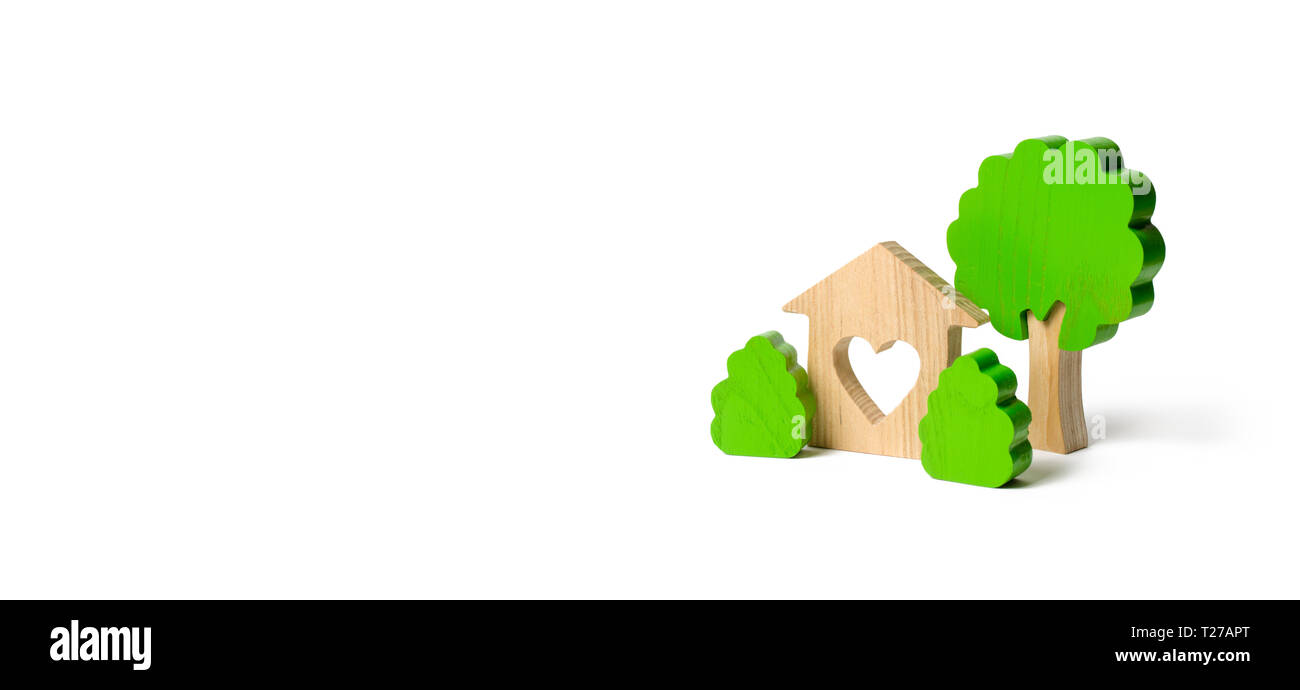 Une maison avec un coeur et figures en bois d'arbres avec des buissons isolés sur un arrière-plan. nid d'amour. Acquisition de logements abordables dans un prêt hypothécaire ou Banque D'Images