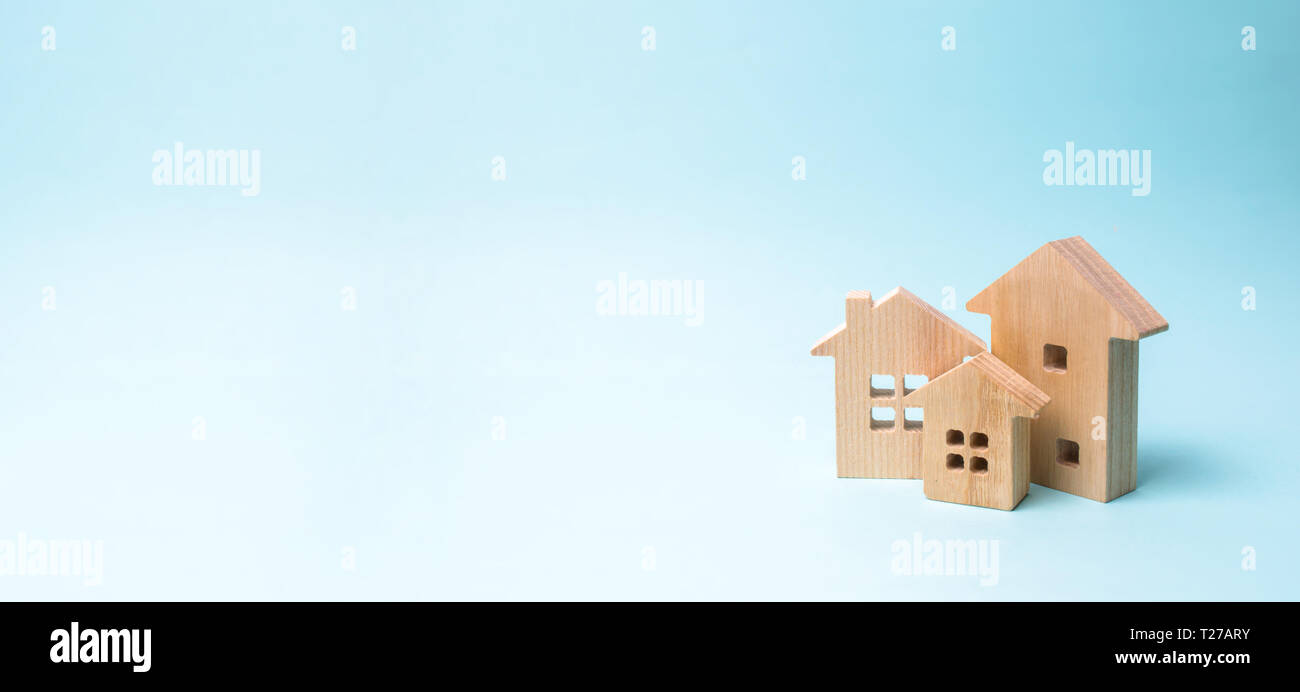 Les maisons en bois sur un fond bleu. Les jouets en bois. Le concept de l'immobilier et de la propriété, l'achat d'une propriété. Ferme, ville, village, entreprise. Cons Banque D'Images