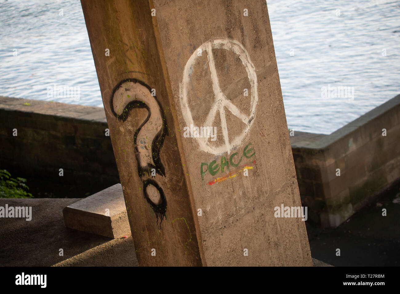 Des graffitis sur des appuis du pont - Point d'interrogation et de la paix la paix dans le monde, symbole de la CND. Banque D'Images