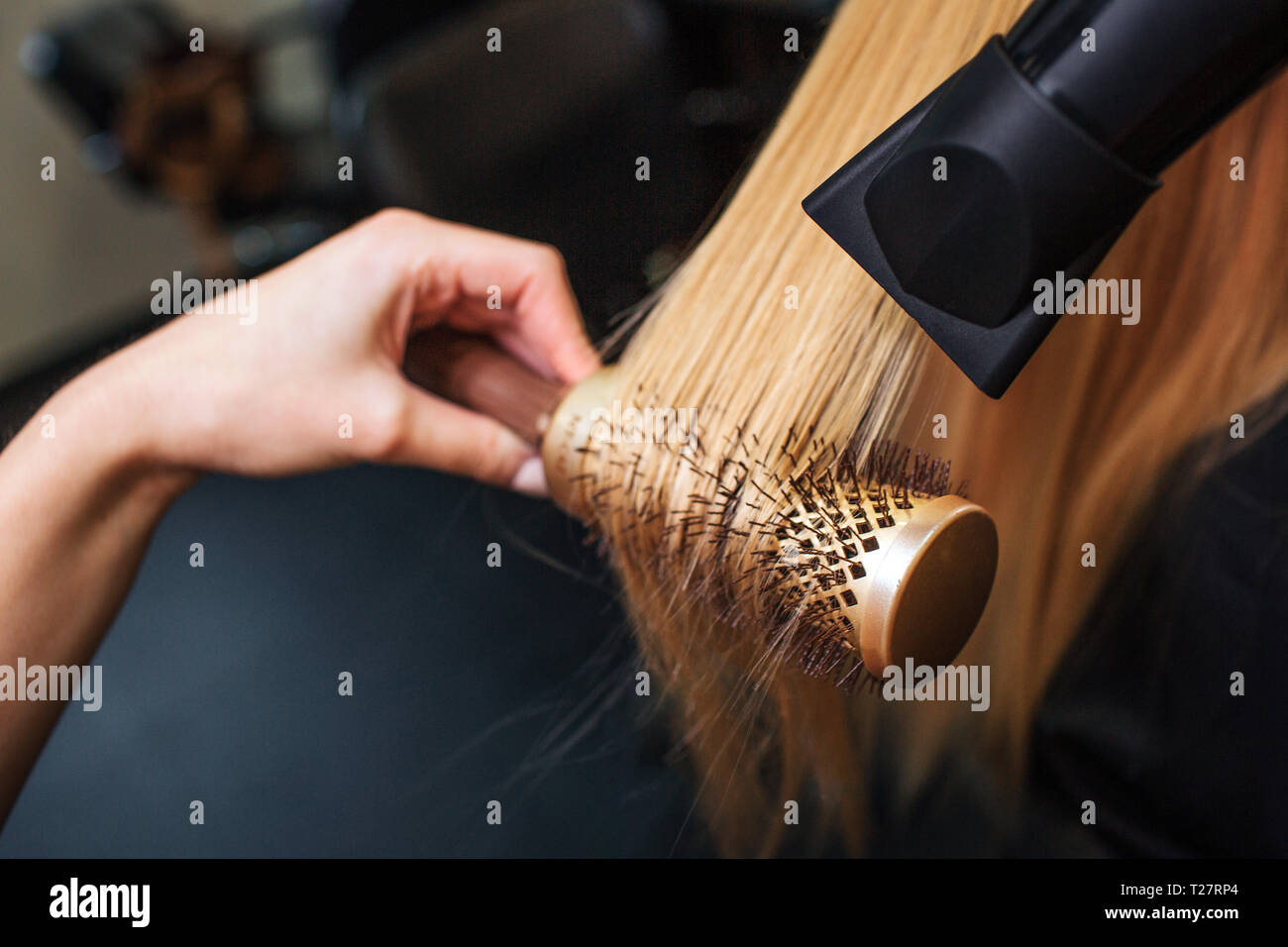 Close-up de coiffeurs le séchage des mains cheveux blonds avec sèche-cheveux et brosse ronde. Salon de coiffure à faire Banque D'Images