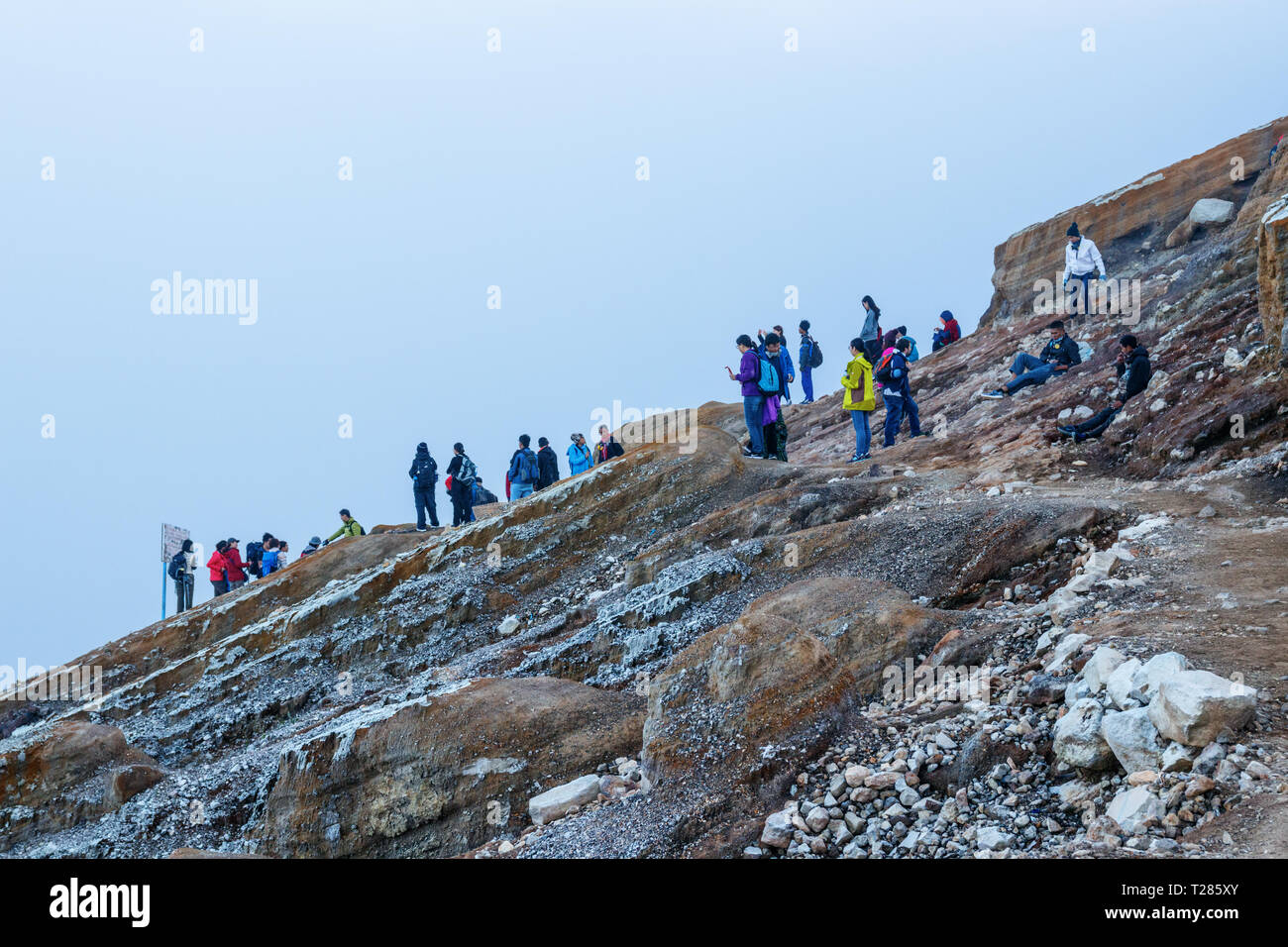 Vue sur le Kawah Ijen crater et encombrée de touristes et avec sulferic toxiques sortant du bas. L'île de Java en Indonésie. Banque D'Images
