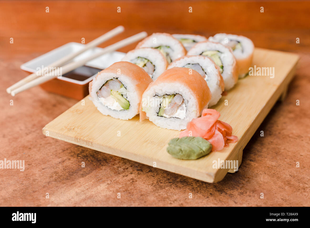 Bien rouler avec du gingembre, wasabi et sauce de soja sur une table en bois Banque D'Images