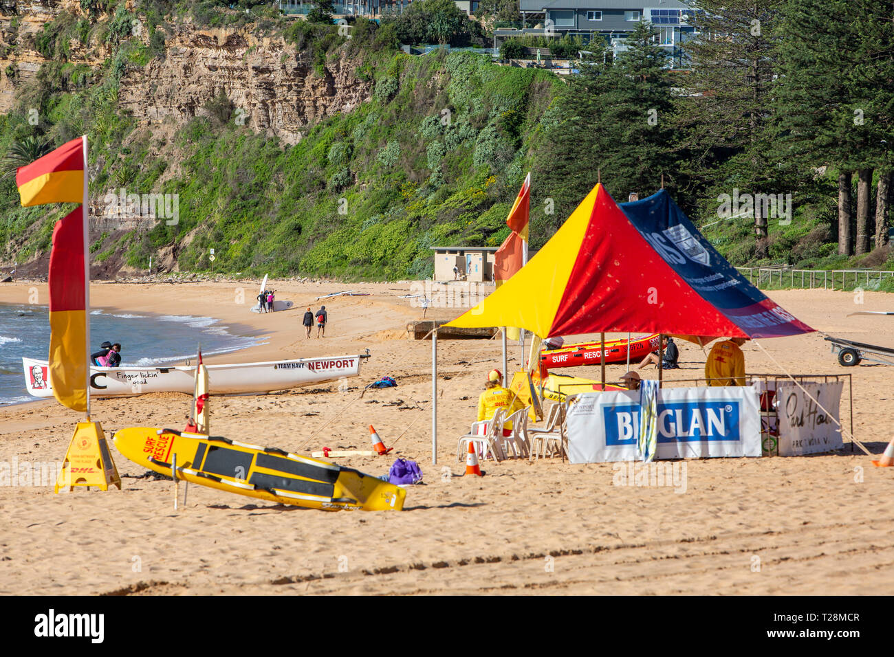 Surf sauvetage volontaires sur Newport Beach à Sydney, en Australie avec des drapeaux rouges et jaunes de plage et une tente ombragée Banque D'Images
