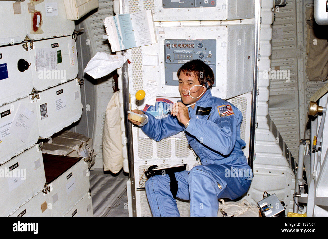 11-15 nov.) 1982 --- L'astronaute Joseph P. Allen IV, spécialiste de  mission STS-5, regarde un globule de jus d'orange flotte librement quelques  instants après qu'il a créé la balle à l'aide de