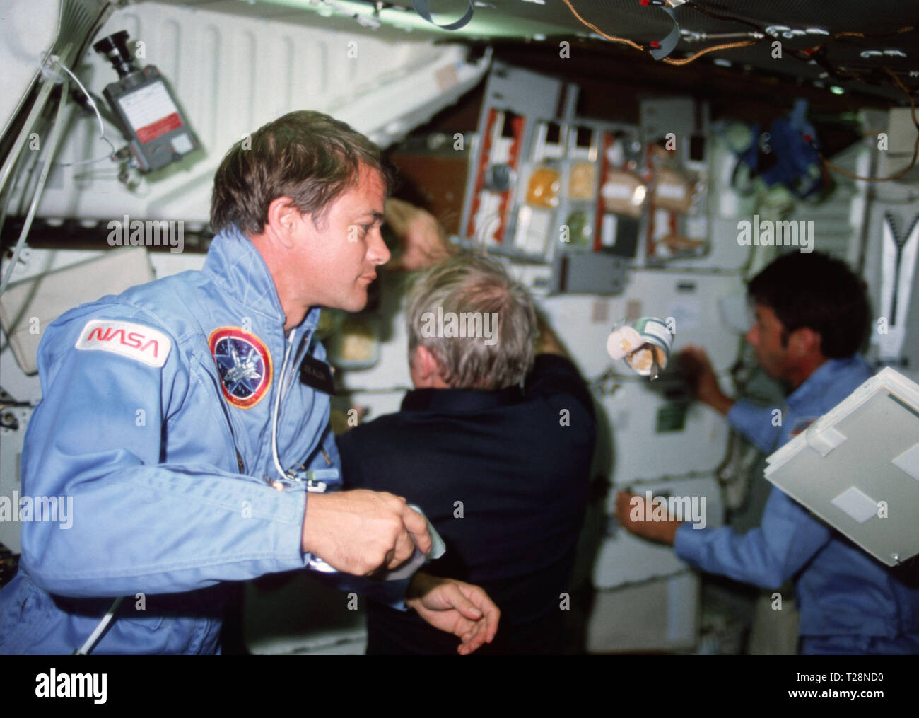 11-16 nov.) 1982 --- L'astronaute Joseph P. Allen, spécialiste de mission  STS-5, montres un peut de nourriture et d'un ordinateur portable dans le  compartiment intermédiaire de la dérive comme C. Vance Brand,