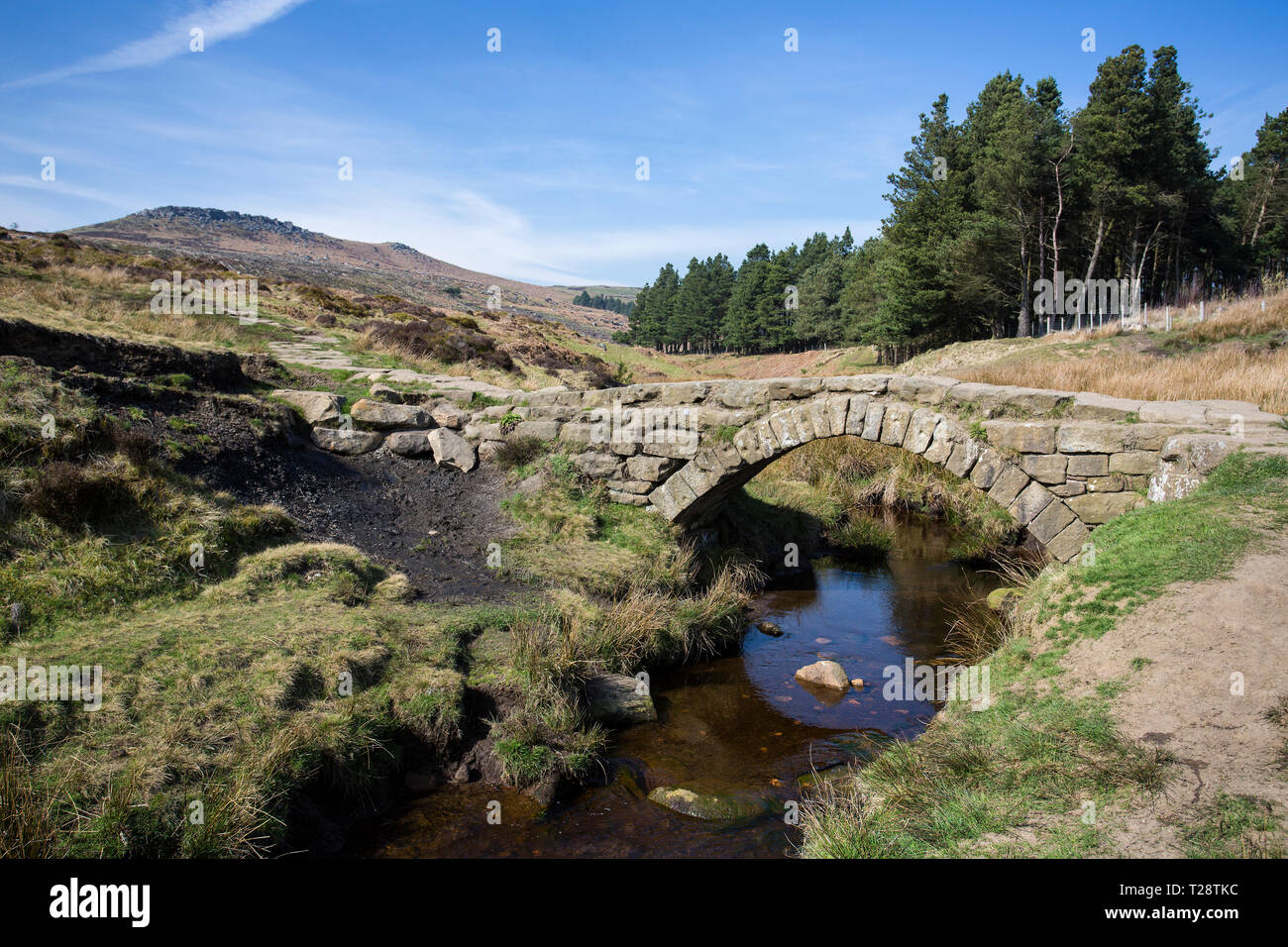 Un vieux pont de pierre pour les charrettes sur un petit ruisseau dans le Peak District National Park Banque D'Images