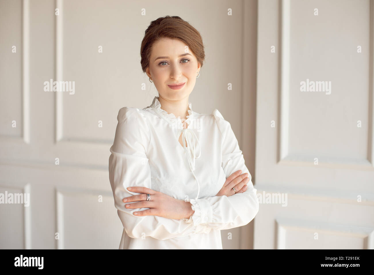 Portrait d'une belle jeune femme d'affaires dans une chemise blanche et un  pantalon noir avec une coiffure d'une gerbe de brunette au bureau Photo  Stock - Alamy