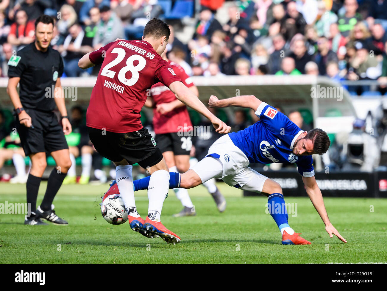 Hanovre, Allemagne. Mar 31, 2019. Schalke 04 Mark Chu (R) rivalise avec Hanovre 96's Kevin Wimmer lors d'un match de Bundesliga allemande entre Hanovre 96 et le FC Schalke 04, à Hanovre, en Allemagne, le 31 mars 2019. Schalke 04 a gagné 1-0. Crédit : Kevin Voigt/Xinhua/Alamy Live News Banque D'Images