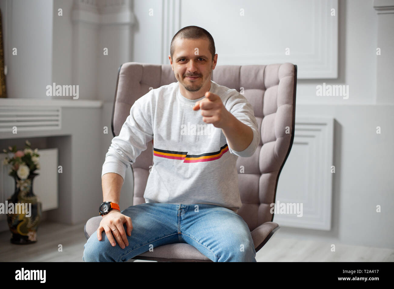 L'homme à la caméra et le pointant vers vous tout en restant assis sur le canapé ou chaise Banque D'Images