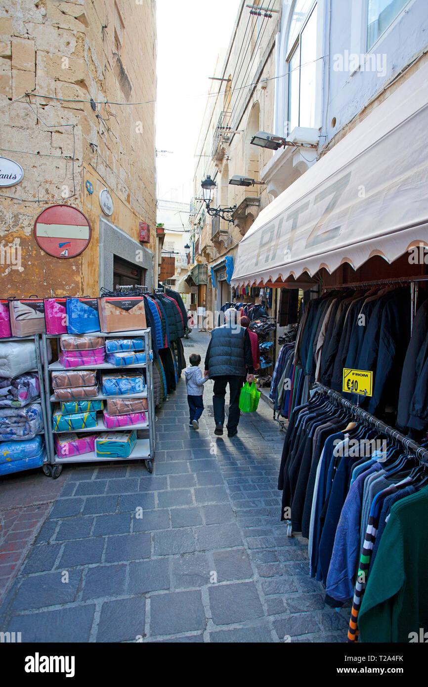 Homme marchant avec des articles passés pour enfant à vendre sur le marché extérieur Banque D'Images