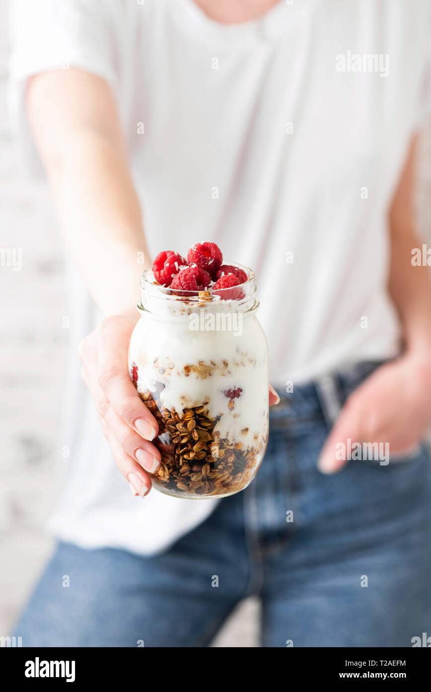 Pot de yaourt muesli parfait à main de la jeune fille. Régime alimentaire équilibré repas. La culture alimentaire à la mode Banque D'Images