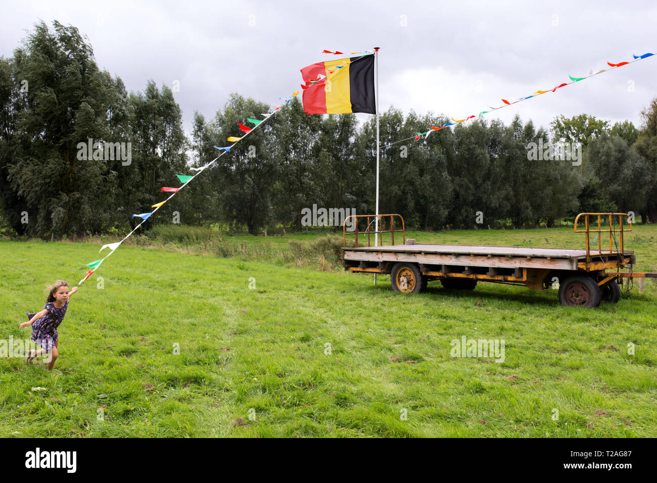 DIKKELVENNE - une fille court dans un champ avec le drapeau belge sur le village chaque année juste Banque D'Images