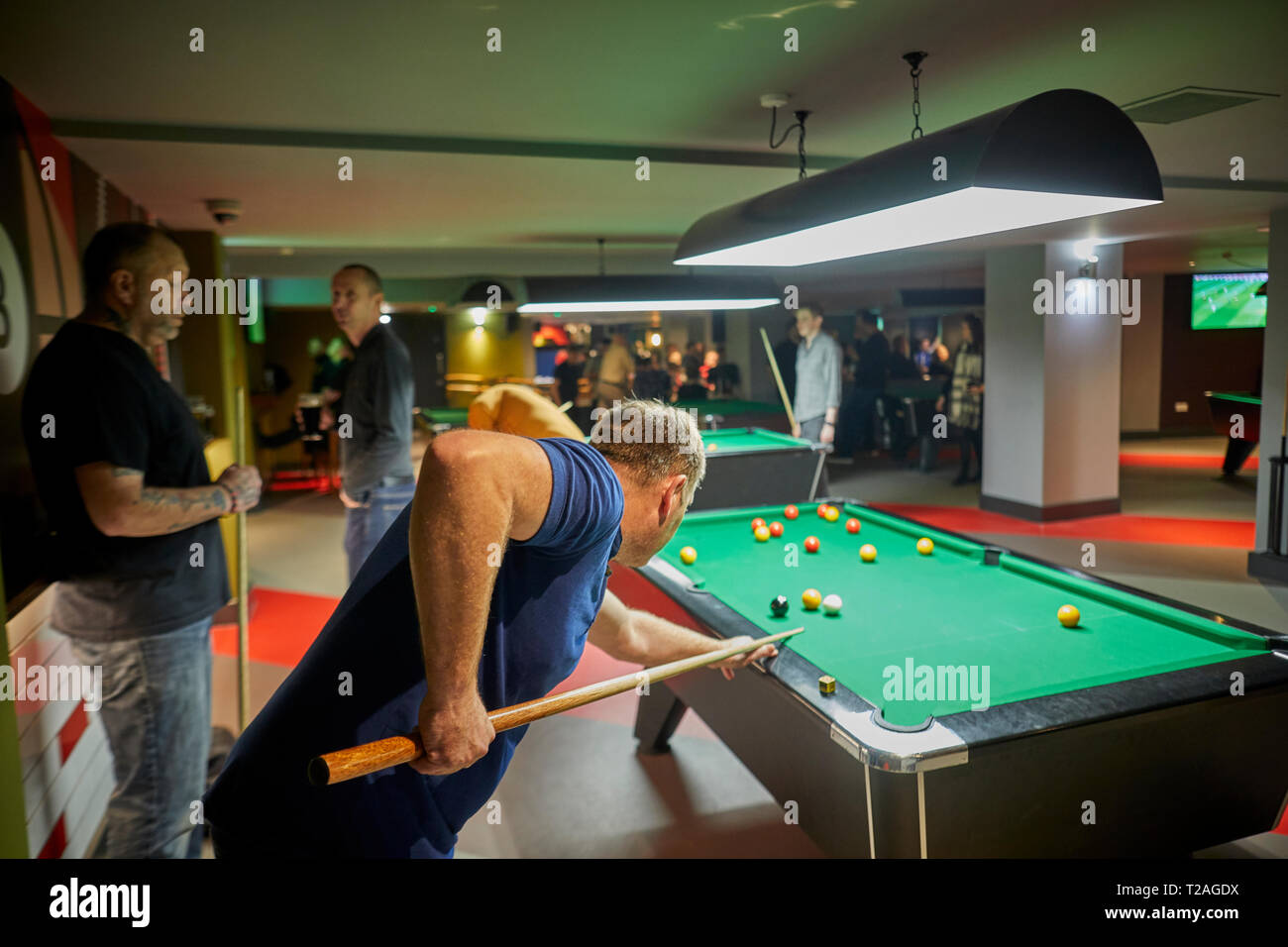 Jeune homme jouant au billard dans la salle de billard Banque D'Images