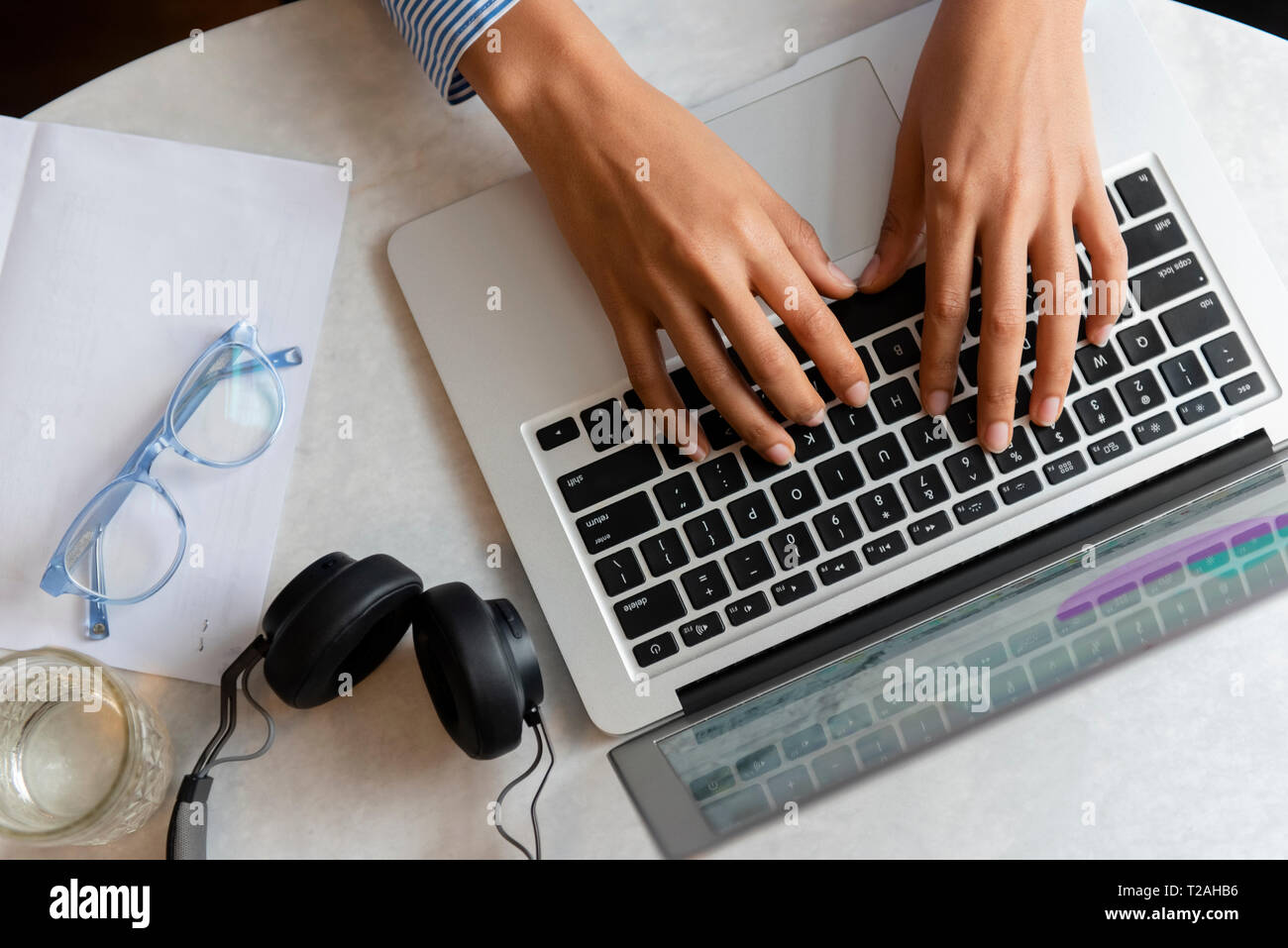 High angle view of young woman's hands typing on laptop Banque D'Images