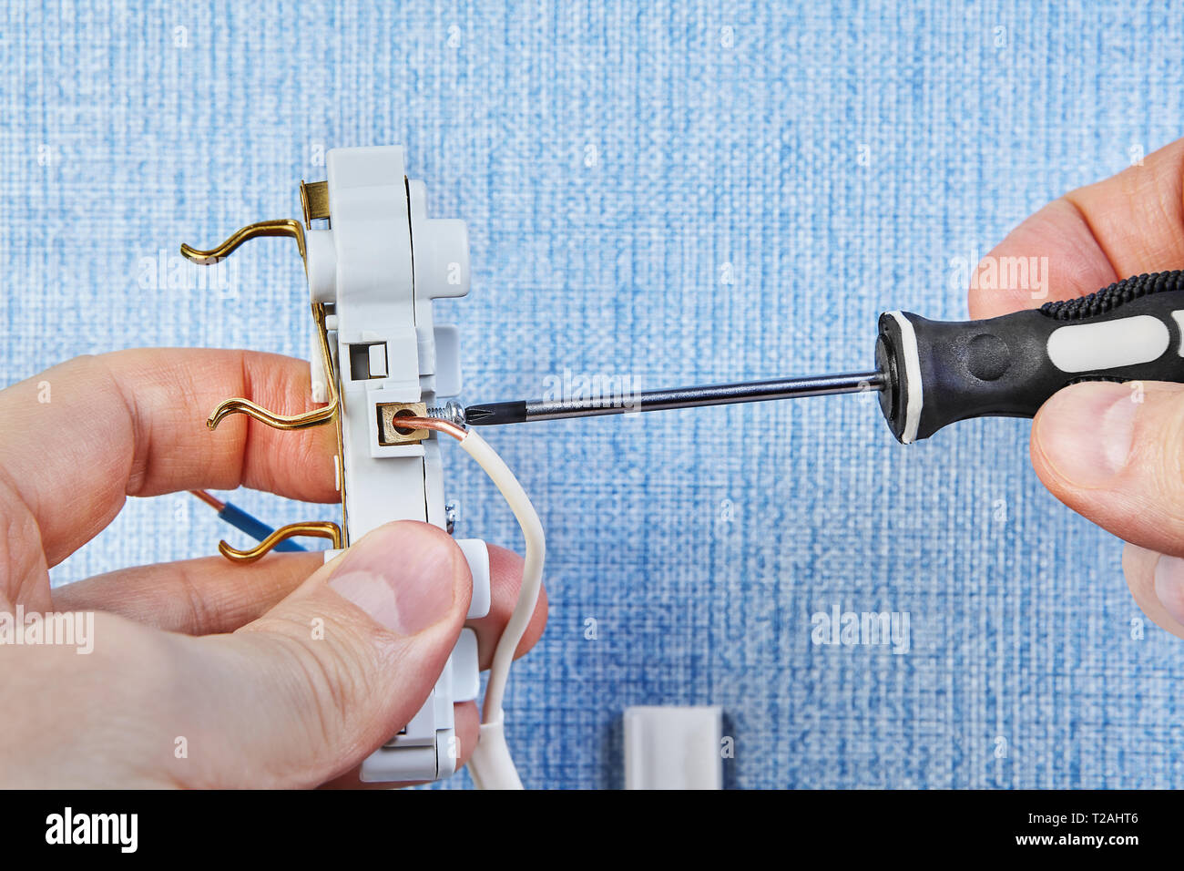 Électricien est tordant dans de nouvelles vis de prise électrique avec  l'aide de tournevis Photo Stock - Alamy