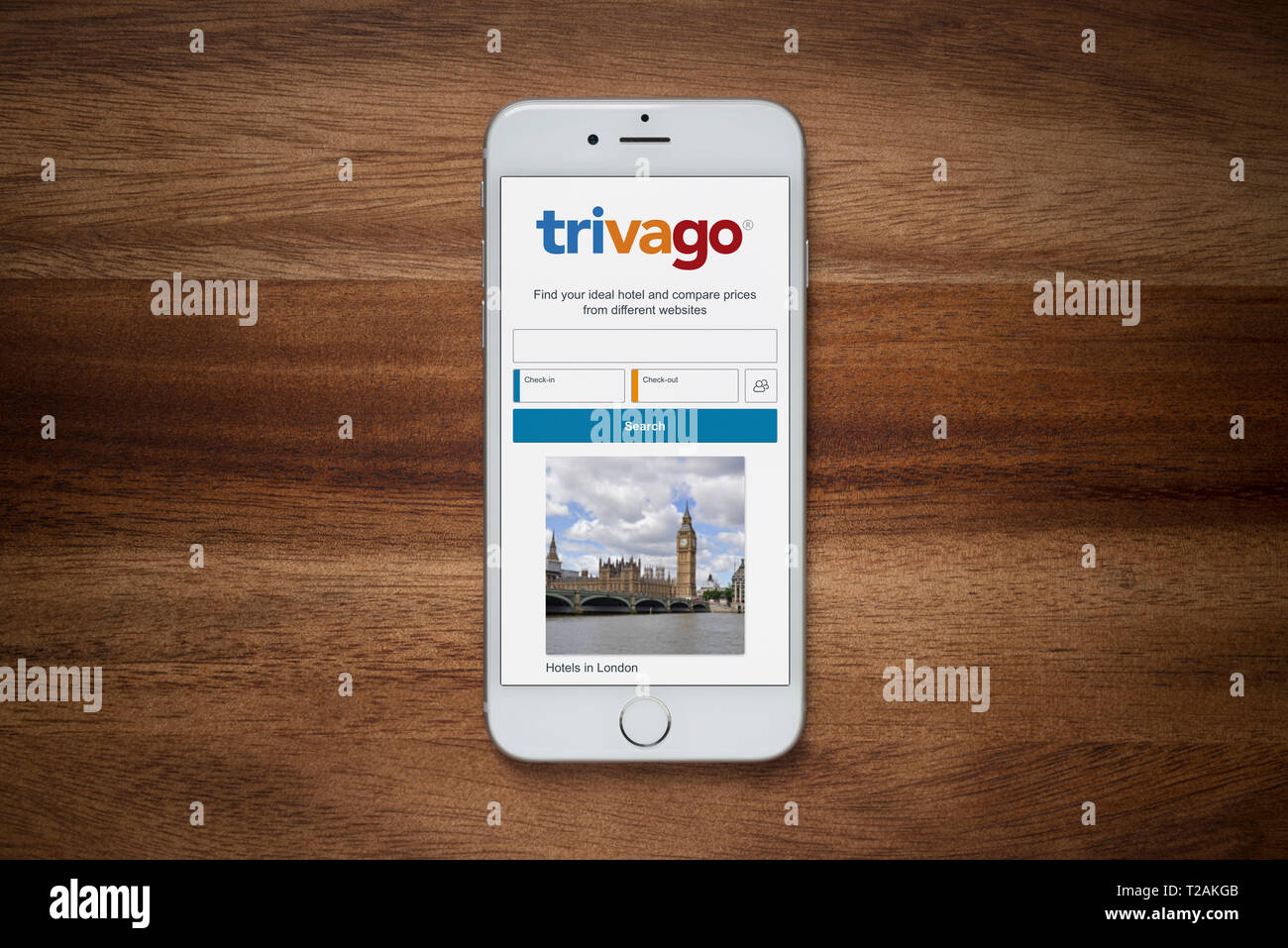 Un iPhone montrant le site Trivago repose sur une table en bois brut (usage éditorial uniquement). Banque D'Images