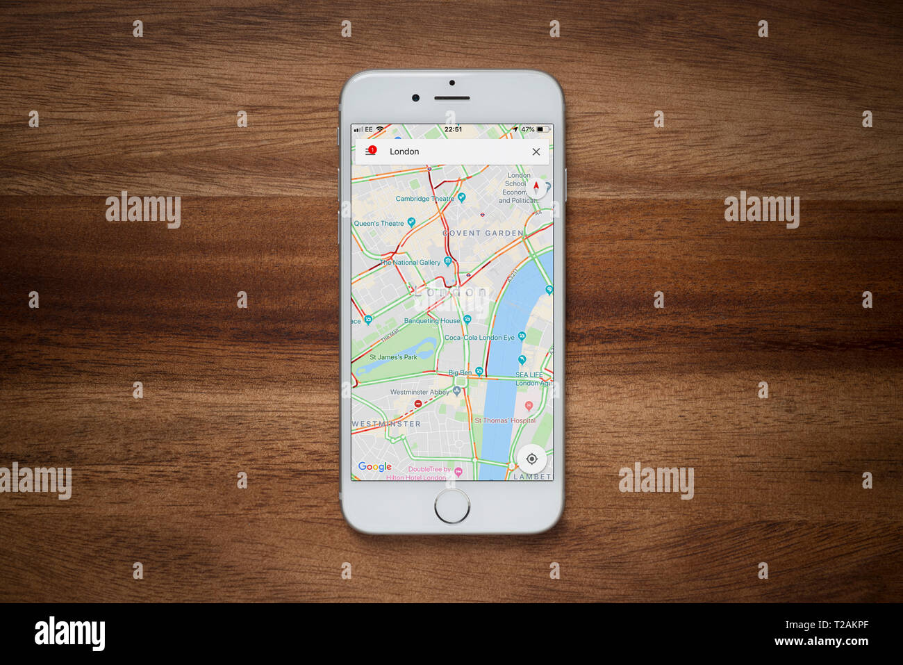 Un iPhone montrant le site Google Maps repose sur une table en bois brut (usage éditorial uniquement). Banque D'Images