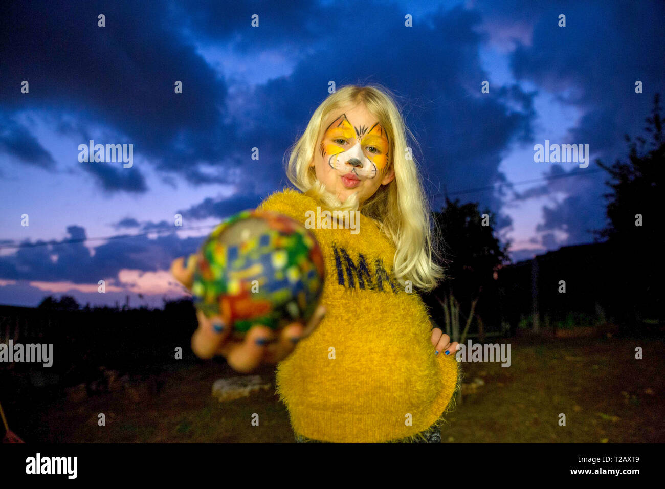 Jeune fille avec tiger masque maquillage se prépare pour Pourim publié modèle. Banque D'Images