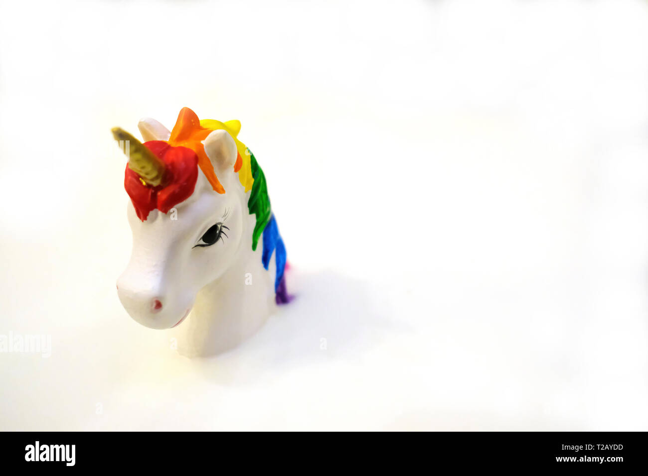 Unicorn coloré jouet avec corne d'or sur fond blanc Banque D'Images