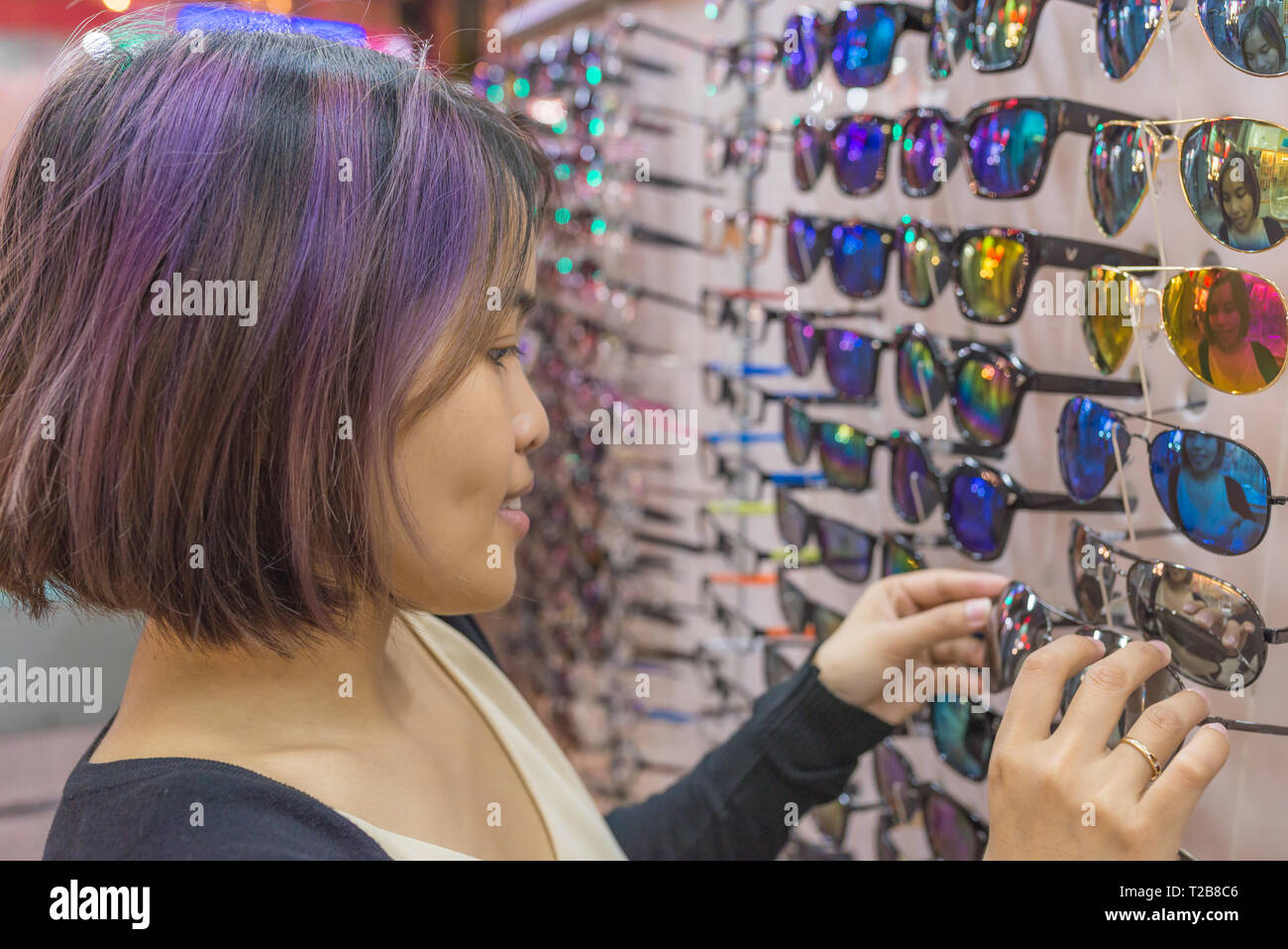 Jeune fille avec des cheveux violets choisir des verres Banque D'Images