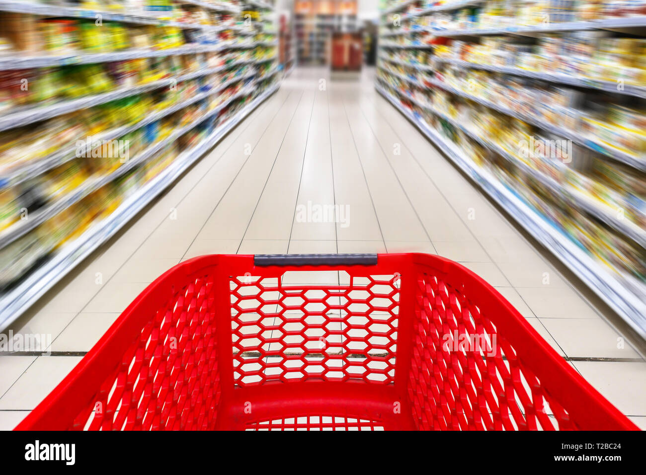 Panier vide rouge dans une allée de supermarché, le motion blur Banque D'Images