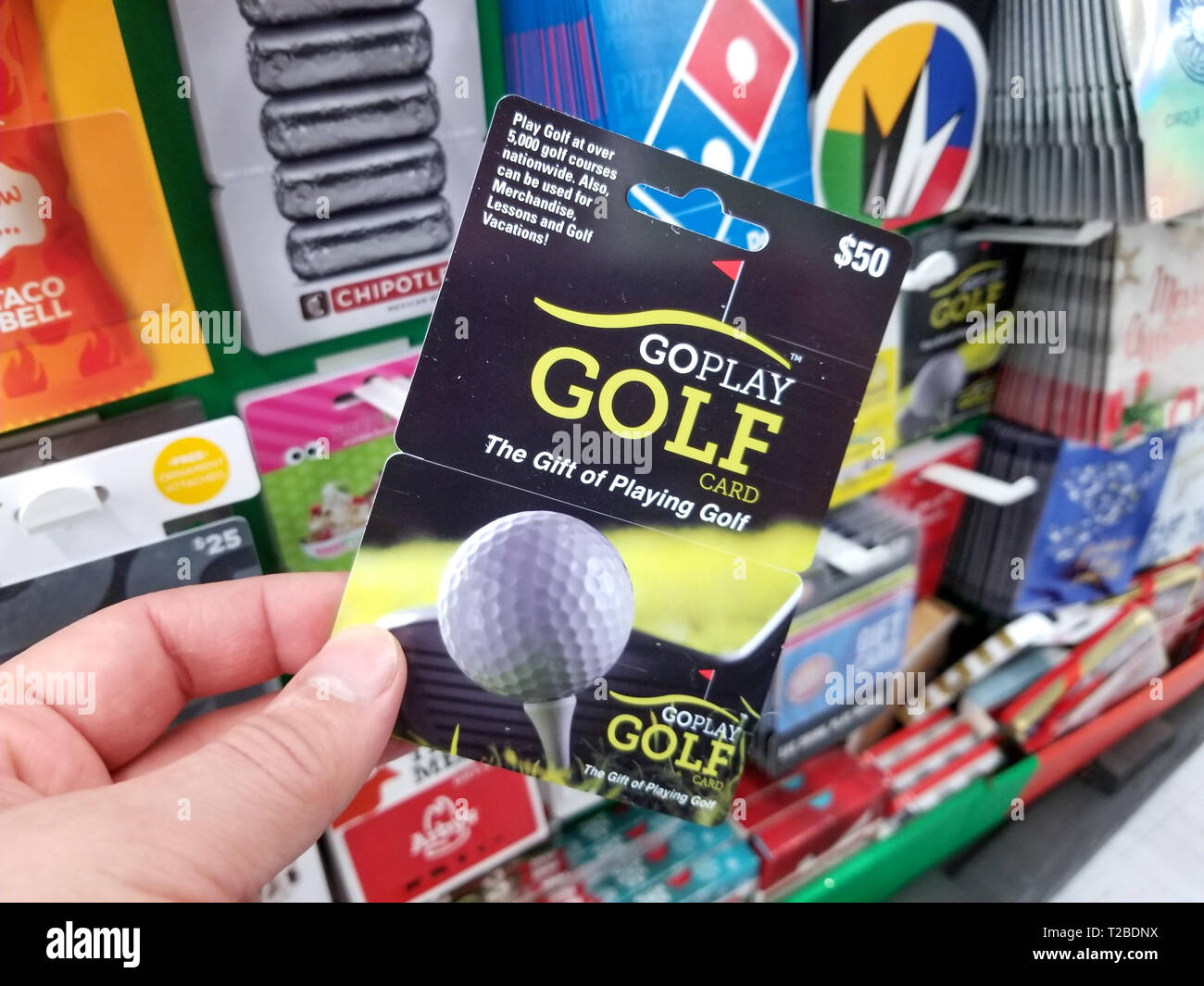 PLATTSBURGH, USA - Le 21 janvier 2019 : carte cadeau Golf Goplay dans une main sur une étagère avec différentes les cartes-cadeaux dans un magasin Walmart. Banque D'Images