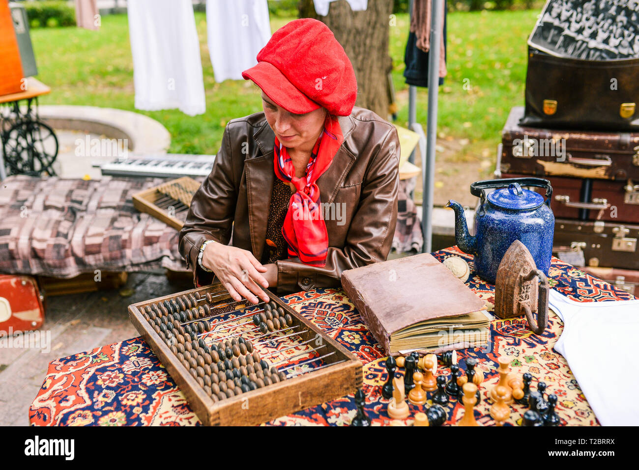 La Russie, Moscou ville - septembre 6, 2014 : une femme avec une veste en cuir et un béret rouge compte sur une carte de comptage. Conseil de comptage avec des os sur l'at Banque D'Images