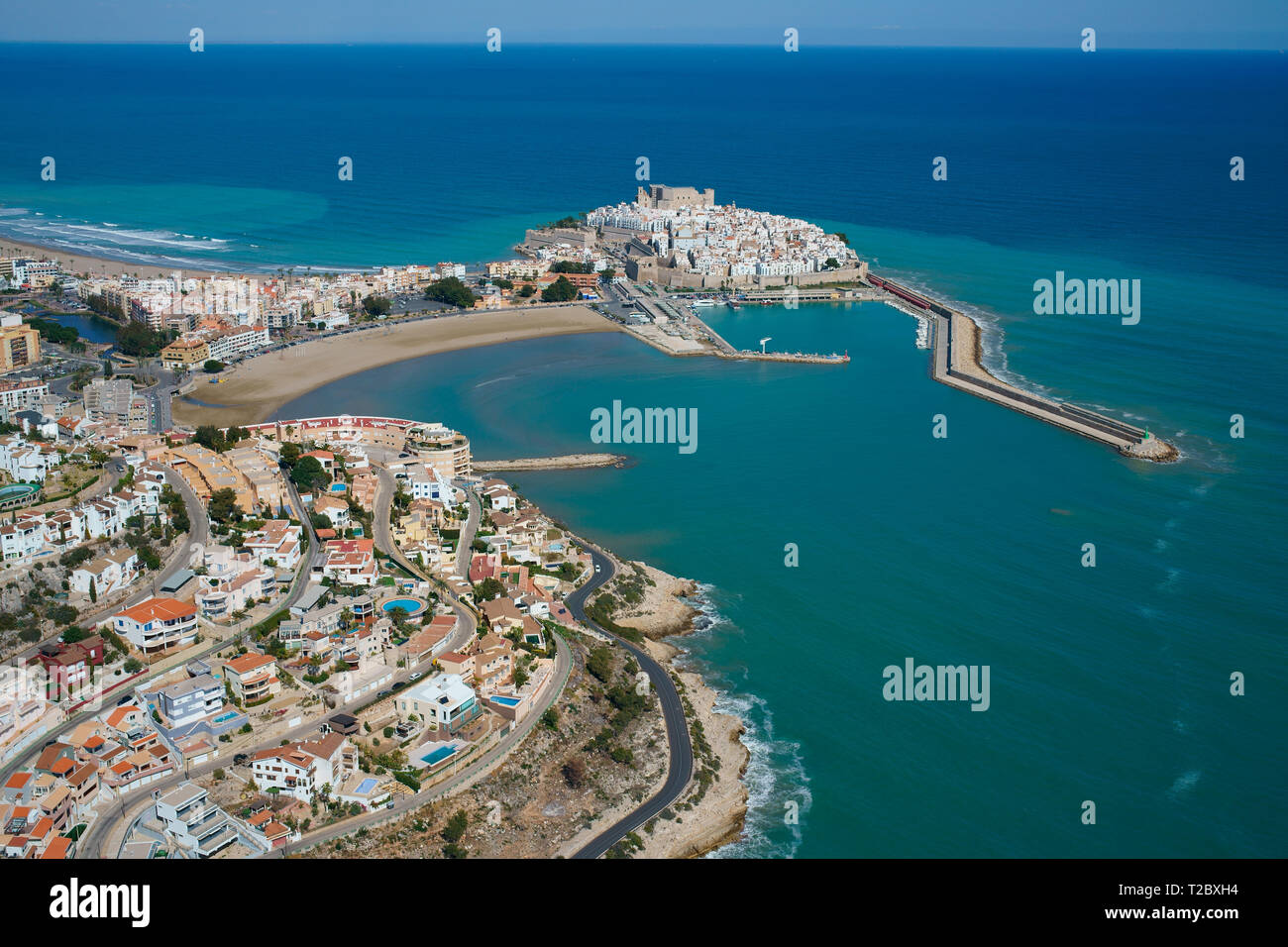 VUE AÉRIENNE. Résidences touristiques surplombant la ville historique sur une péninsule de la côte méditerranéenne. Peñíscola, Communauté Valencienne, Espagne. Banque D'Images