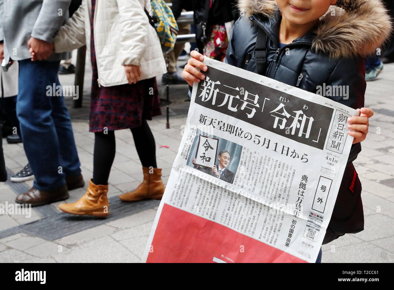 Un garçon est titulaire d'une copie de ces rapports édition d'un journal le nom de la nouvelle ère impériale, 'Reiwa', à Tokyo, au Japon, le 1 avril 2019. Le gouvernement japonais a officiellement annoncé la prochaine ère sera connu sous le nom de "ère" Reiwa le lundi, un mois avant Prince héritier Naruhito monte sur le trône après l'abdication de l'Empereur Akihito. Credit : Naoki Nishimura/AFLO/Alamy Live News Banque D'Images