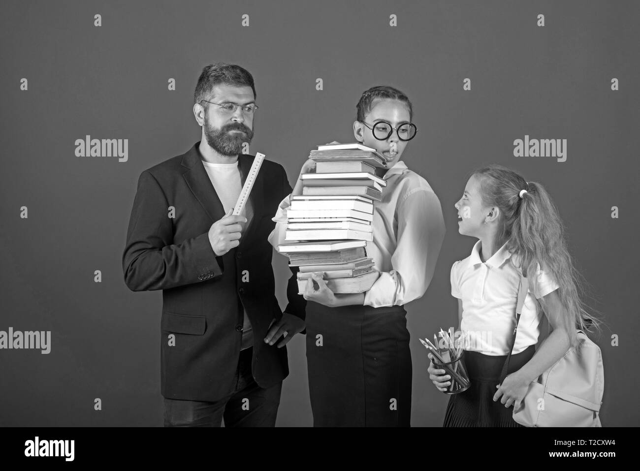 Processus de formation avec de nombreux livres dans les mains des filles avec l'enseignant. formation à l'examen à l'école. Banque D'Images