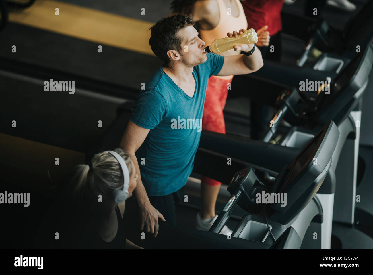 Vue supérieure au groupe de jeunes en cours d'exécution sur des tapis roulants dans la salle de sport moderne Banque D'Images