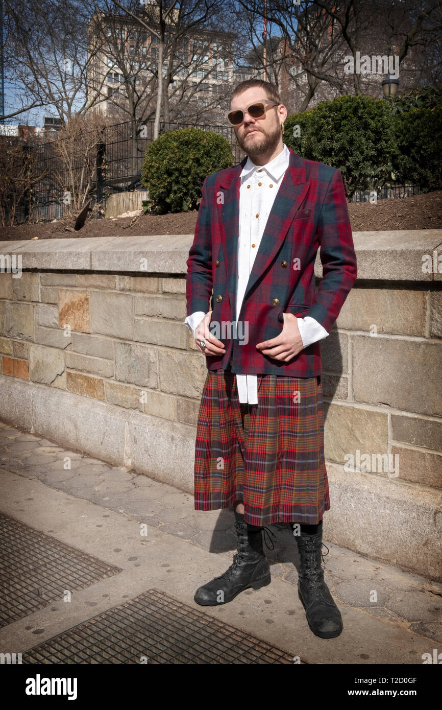 Portrait posé d'un homme portant une jupe à carreaux, une veste à carreaux et une chemise ornée. Dans Union Square Park à Manhattan, New York. Banque D'Images