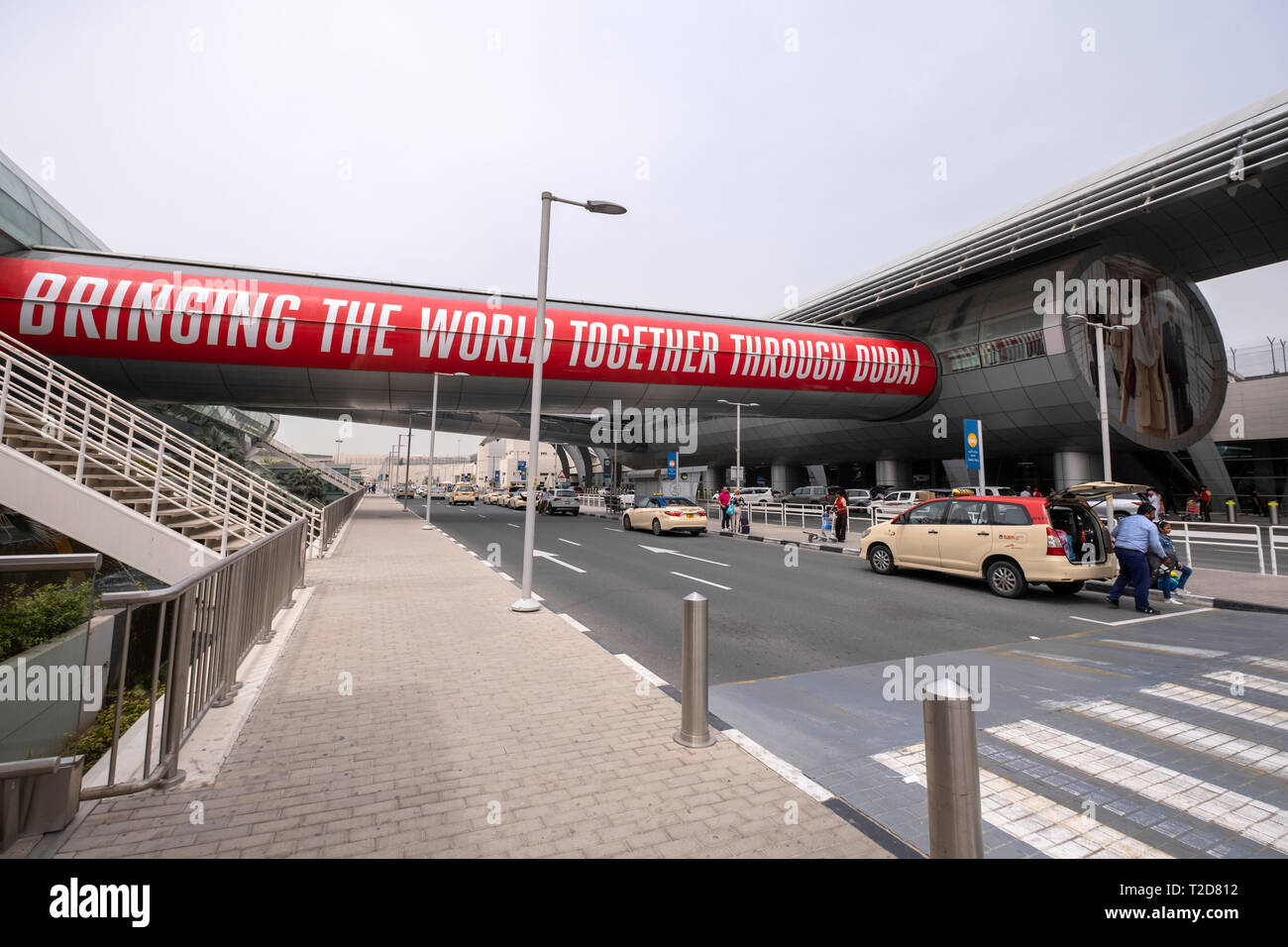 Les passagers qui quittent un taxi pour prendre un avion à l'Aéroport International de Dubaï, Émirats Arabes Unis Banque D'Images