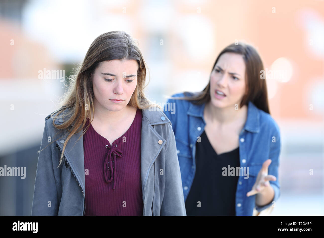 Angry girl scolding a souligné son ami marche dans la rue Banque D'Images