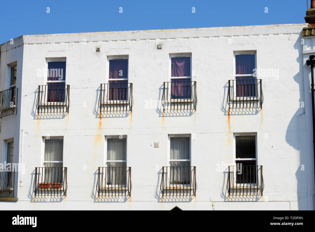 Bâtiment blanc clair avec des taches de rouille sur les balcons Juliette en métal. Peinture blanche abîmée. Balconet, balconettes balconnet sur façade Banque D'Images