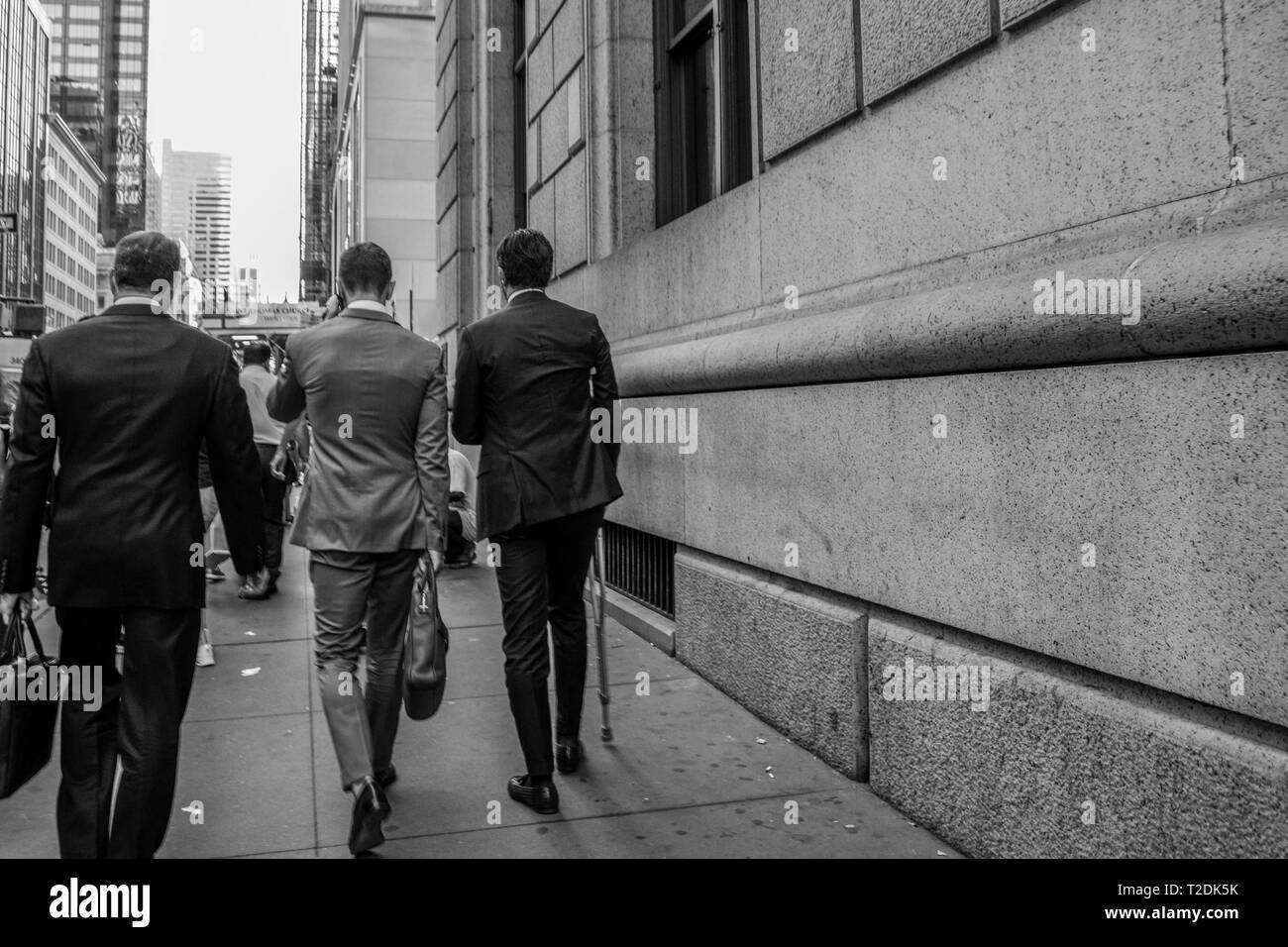 hommes d'affaires avec costume et étuis marchant au travail Banque D'Images