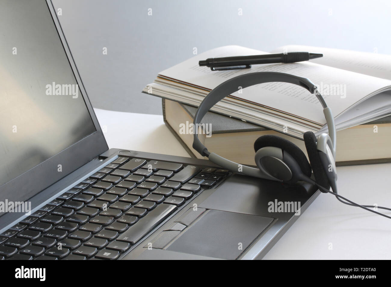 Ordinateur portable sur la table de travail avec des livres, des papiers, un crayon et un casque. Close up stock photo. Banque D'Images