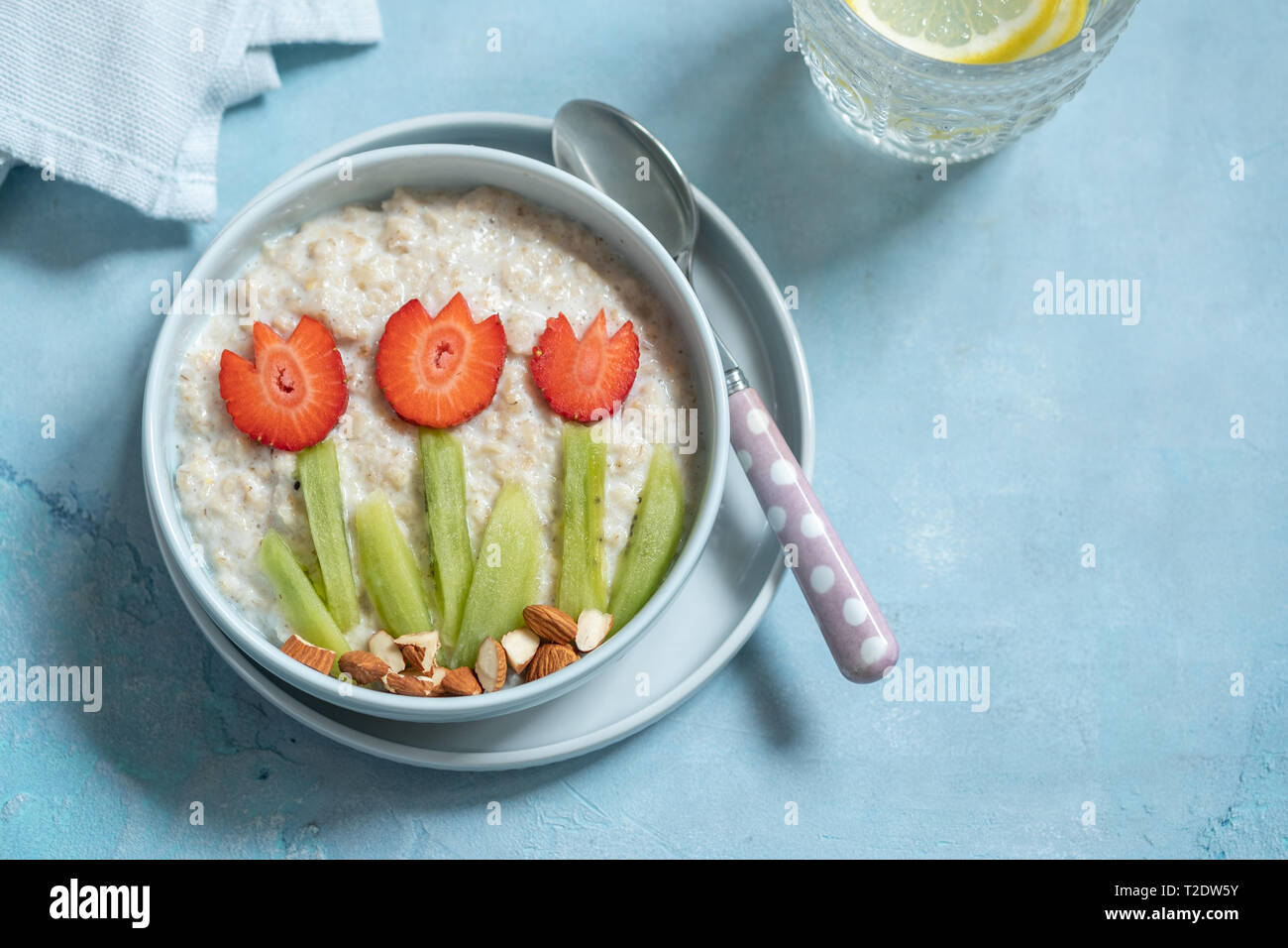 Drôle avec bols de porridge d'avoine avec fleurs de printemps Banque D'Images
