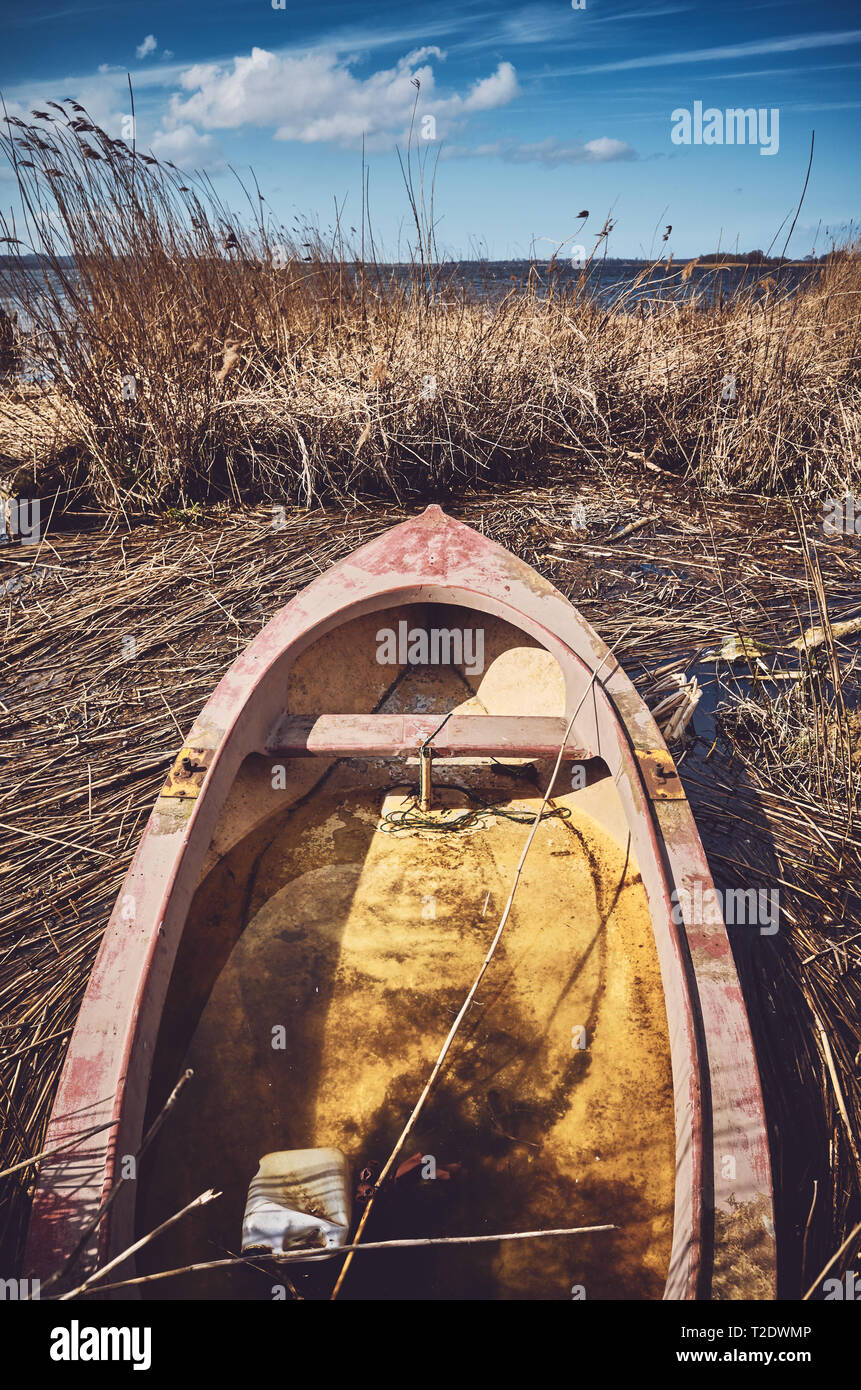Retro photo aux couleurs d'une petite barque de pêche coulé dans les roseaux. Banque D'Images
