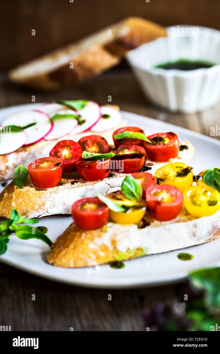 Bruschetta avec tomates cerises et radis à l'huile de basilic Banque D'Images